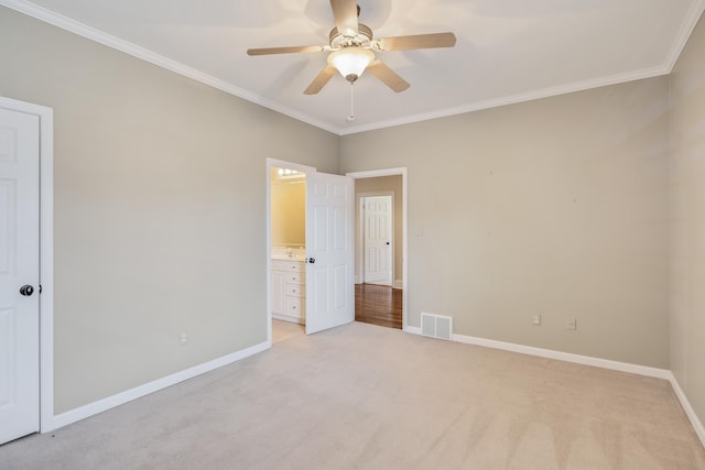 unfurnished bedroom featuring ensuite bath, ceiling fan, crown molding, and light carpet