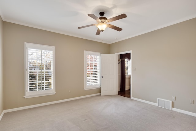 carpeted empty room with ceiling fan and ornamental molding