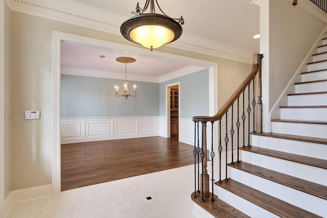 foyer entrance with a chandelier and ornamental molding