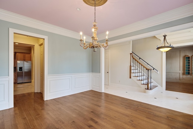 unfurnished room featuring hardwood / wood-style flooring, a notable chandelier, and ornamental molding