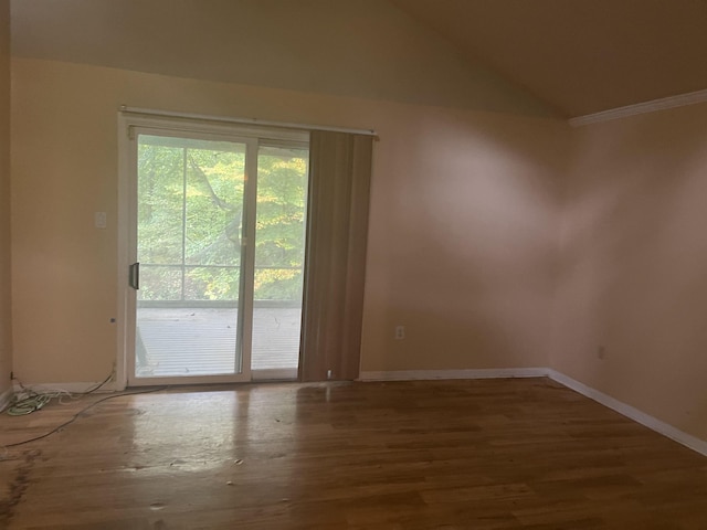 spare room featuring vaulted ceiling, baseboards, and wood finished floors