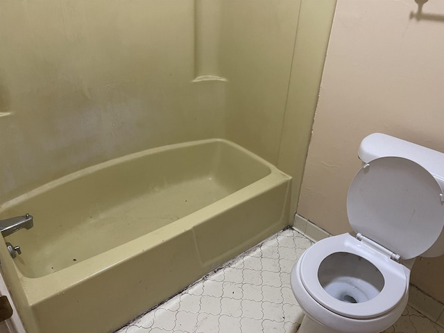 bathroom featuring a bathtub, baseboards, and toilet