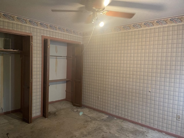 unfurnished bedroom featuring a ceiling fan, a textured ceiling, baseboards, and wallpapered walls