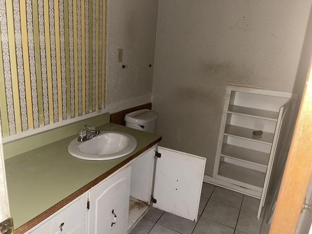 bathroom with tile patterned flooring, vanity, and toilet