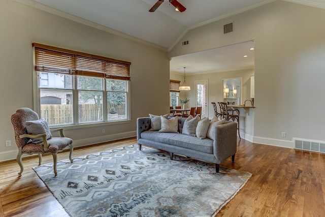 living room with ceiling fan, crown molding, vaulted ceiling, and hardwood / wood-style flooring