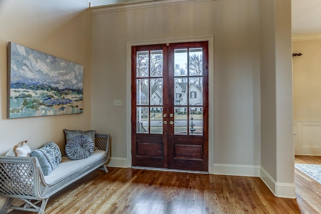 foyer with hardwood / wood-style flooring, french doors, and ornamental molding