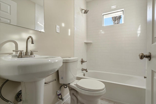 bathroom featuring toilet and tiled shower / bath