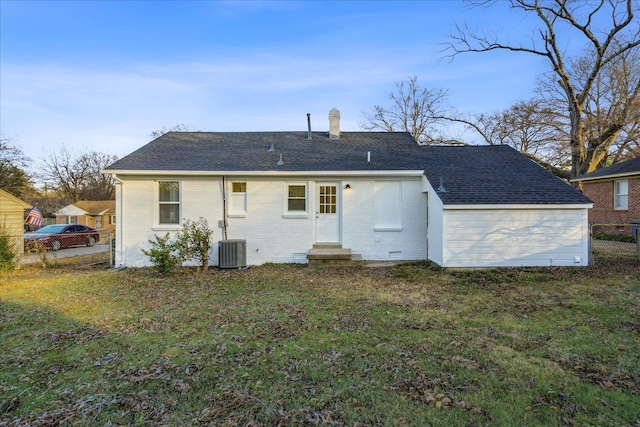 back of property featuring central AC unit and a yard