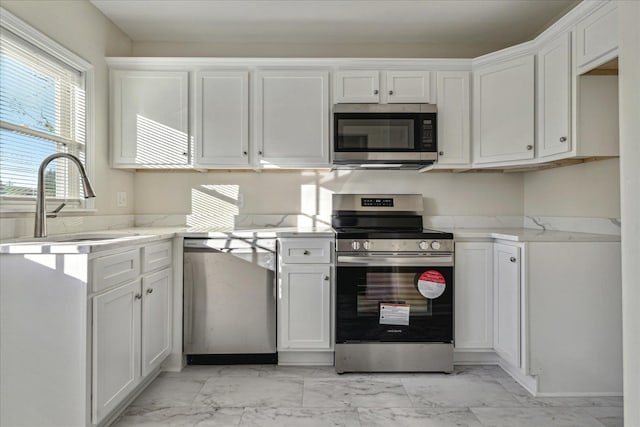 kitchen with white cabinets, stainless steel appliances, and sink