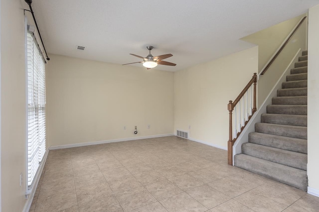 tiled empty room featuring ceiling fan