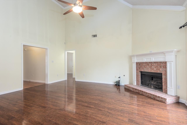 unfurnished living room with a fireplace, a high ceiling, ceiling fan, and crown molding