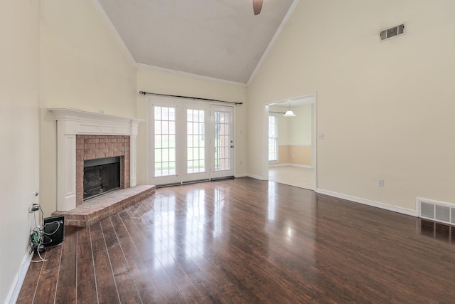 unfurnished living room with hardwood / wood-style flooring, ornamental molding, a fireplace, and high vaulted ceiling