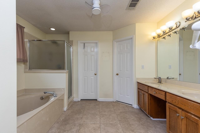 bathroom with vanity, a textured ceiling, ceiling fan, plus walk in shower, and tile patterned flooring