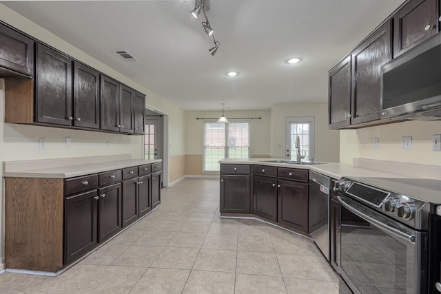 kitchen with kitchen peninsula, sink, dark brown cabinets, and appliances with stainless steel finishes