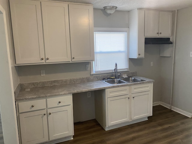 kitchen with dark hardwood / wood-style flooring, a textured ceiling, white cabinetry, and sink