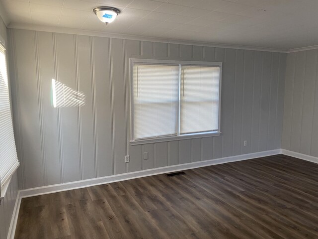 empty room featuring dark hardwood / wood-style floors and ornamental molding