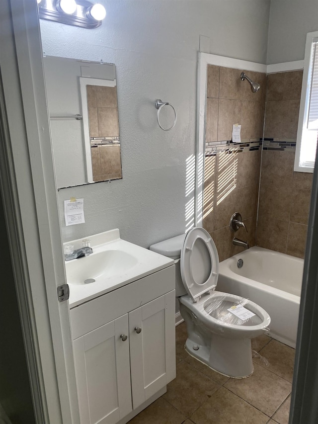 full bathroom with tile patterned flooring, tiled shower / bath combo, toilet, and vanity