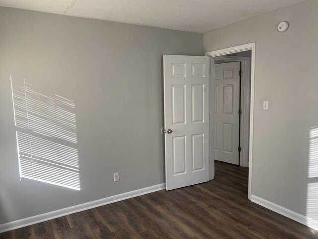 empty room with dark hardwood / wood-style floors