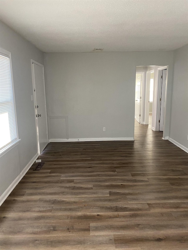 spare room with dark hardwood / wood-style flooring and a textured ceiling