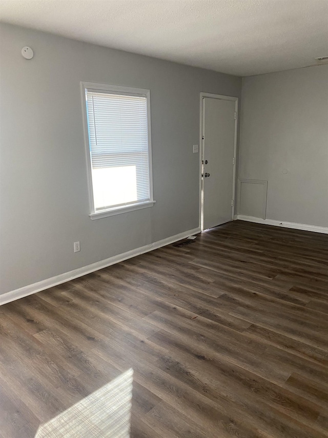 unfurnished room with dark hardwood / wood-style floors