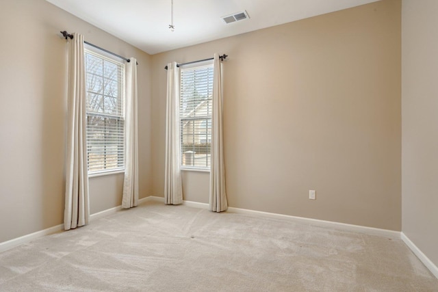 spare room featuring light colored carpet