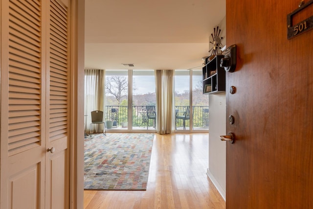 interior space featuring floor to ceiling windows and light wood-type flooring