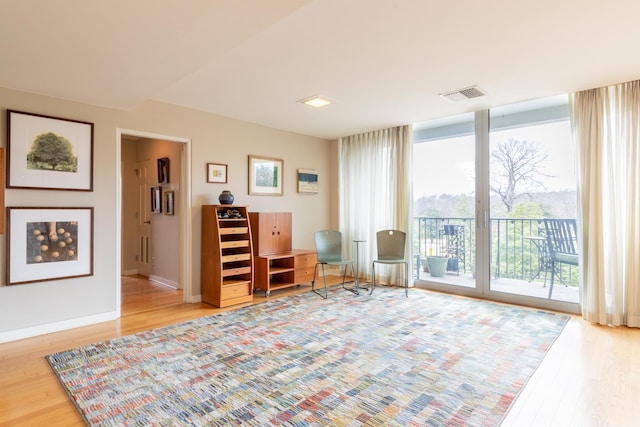 living area with light hardwood / wood-style flooring and floor to ceiling windows