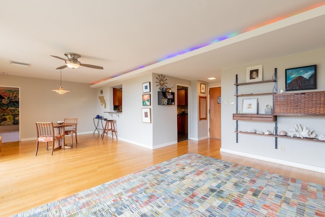 living room featuring ceiling fan and light hardwood / wood-style floors