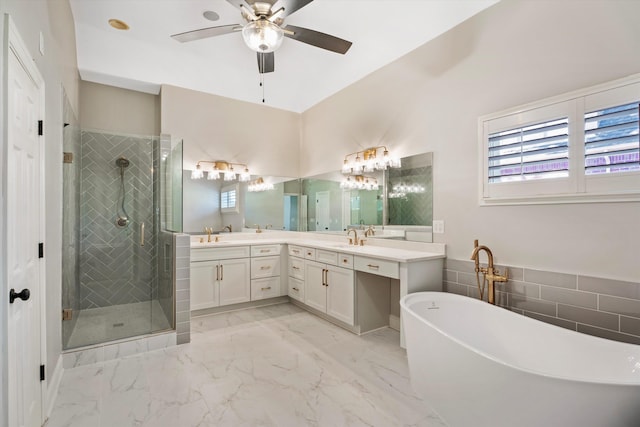 bathroom featuring ceiling fan, vanity, and shower with separate bathtub