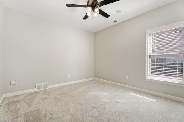 spare room featuring carpet flooring, ceiling fan, and a wealth of natural light