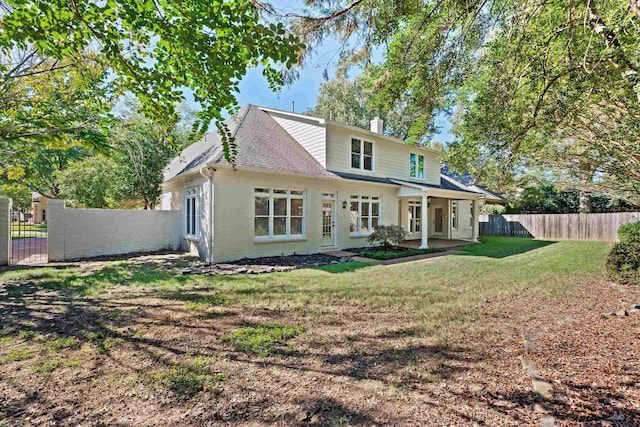 back of house with a yard and a patio