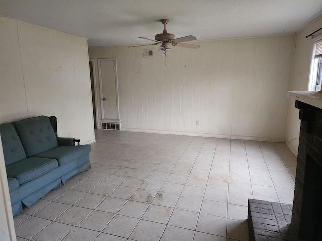 living room with ceiling fan, light tile patterned flooring, and a brick fireplace