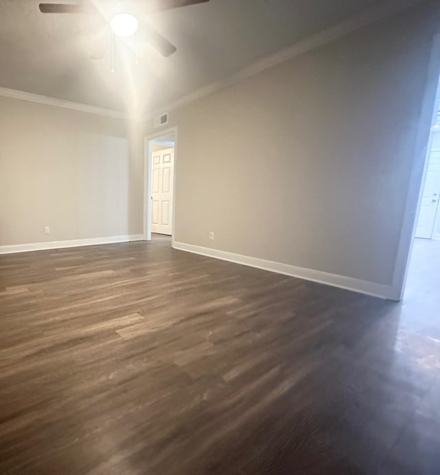 spare room featuring ceiling fan, dark hardwood / wood-style flooring, and crown molding