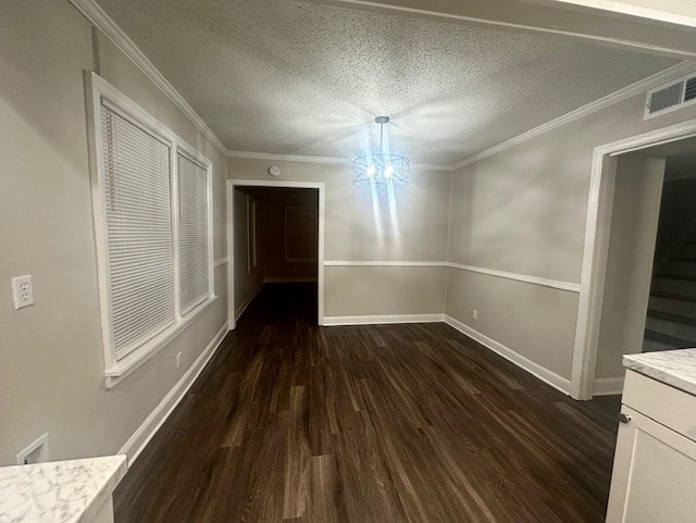 unfurnished dining area with dark hardwood / wood-style flooring, ornamental molding, a textured ceiling, and an inviting chandelier