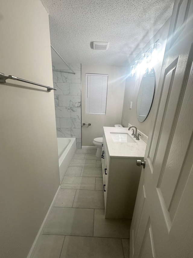 full bathroom with tile patterned floors, vanity, a textured ceiling, toilet, and tiled shower / bath