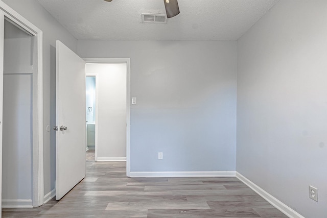 empty room featuring light wood-type flooring and a textured ceiling