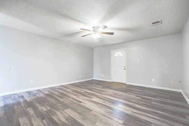 empty room with ceiling fan, dark hardwood / wood-style flooring, and a textured ceiling