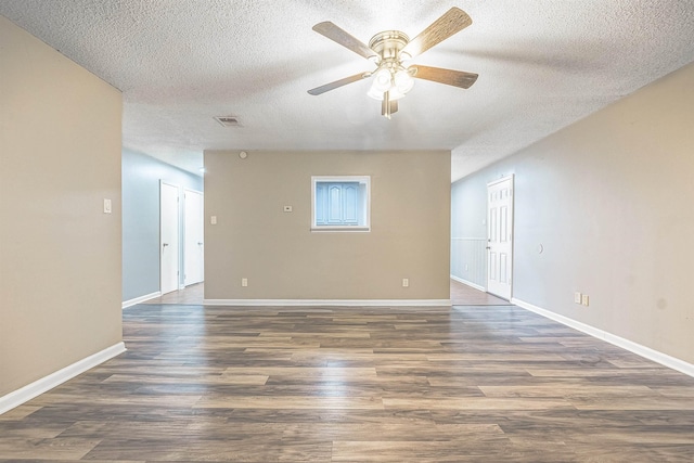 spare room with a textured ceiling, ceiling fan, and dark wood-type flooring