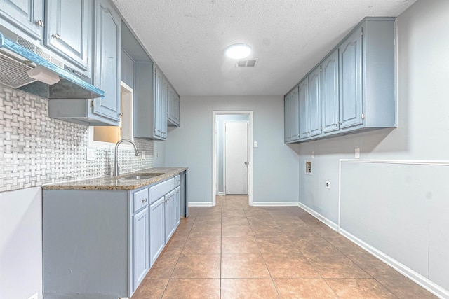 kitchen featuring a textured ceiling, tile patterned floors, and sink