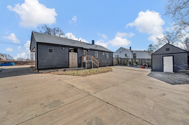 back of property with a storage unit and a patio area