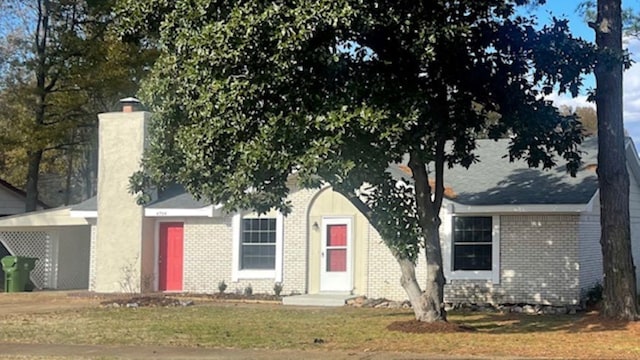 view of property hidden behind natural elements with a front lawn