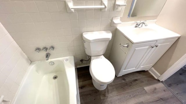 full bathroom featuring hardwood / wood-style floors, vanity, bathtub / shower combination, toilet, and tile walls