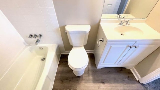 bathroom with hardwood / wood-style floors, a bathtub, toilet, and vanity