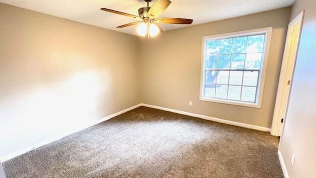 unfurnished room featuring ceiling fan and dark carpet