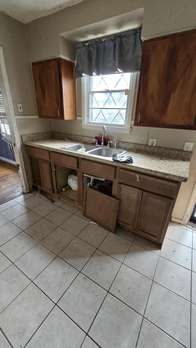 kitchen featuring light tile patterned floors and sink