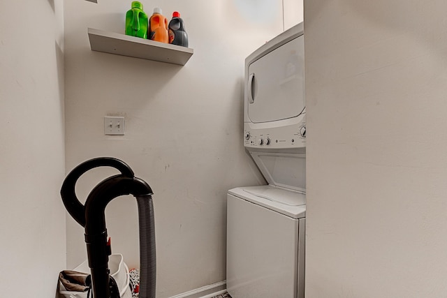 clothes washing area with stacked washer / dryer