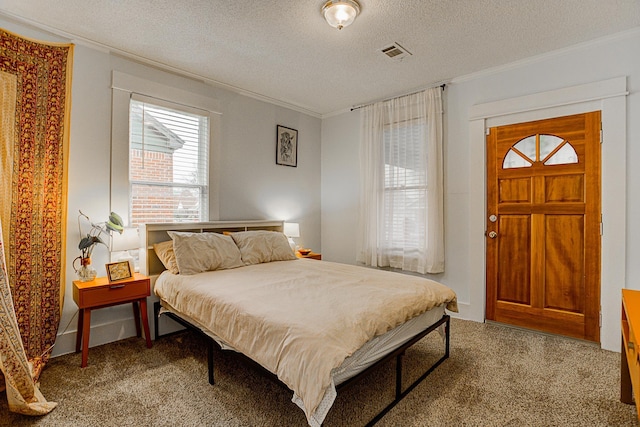 bedroom with a textured ceiling, carpet floors, and ornamental molding