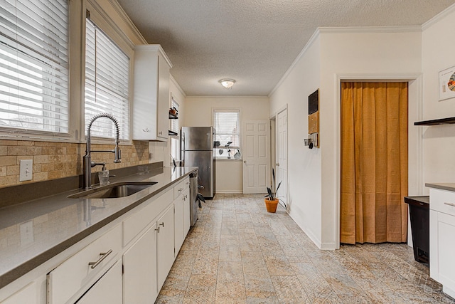 kitchen featuring sink, white cabinets, stainless steel appliances, and ornamental molding