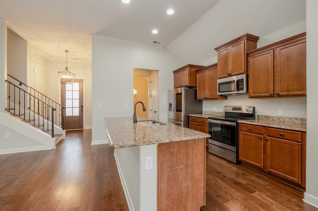 kitchen featuring dark wood-type flooring, a center island with sink, sink, light stone counters, and stainless steel appliances