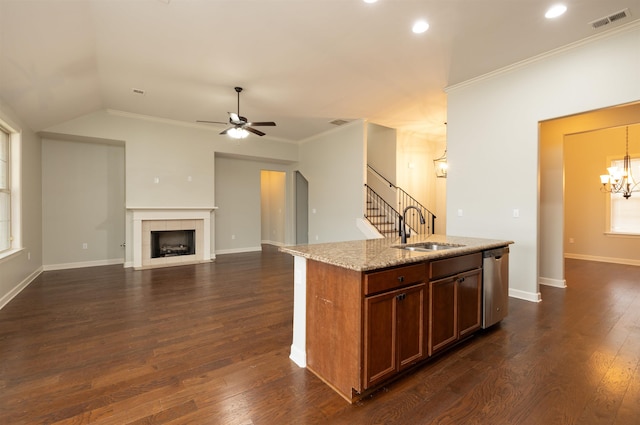 kitchen featuring light stone countertops, crown molding, sink, dishwasher, and a tiled fireplace